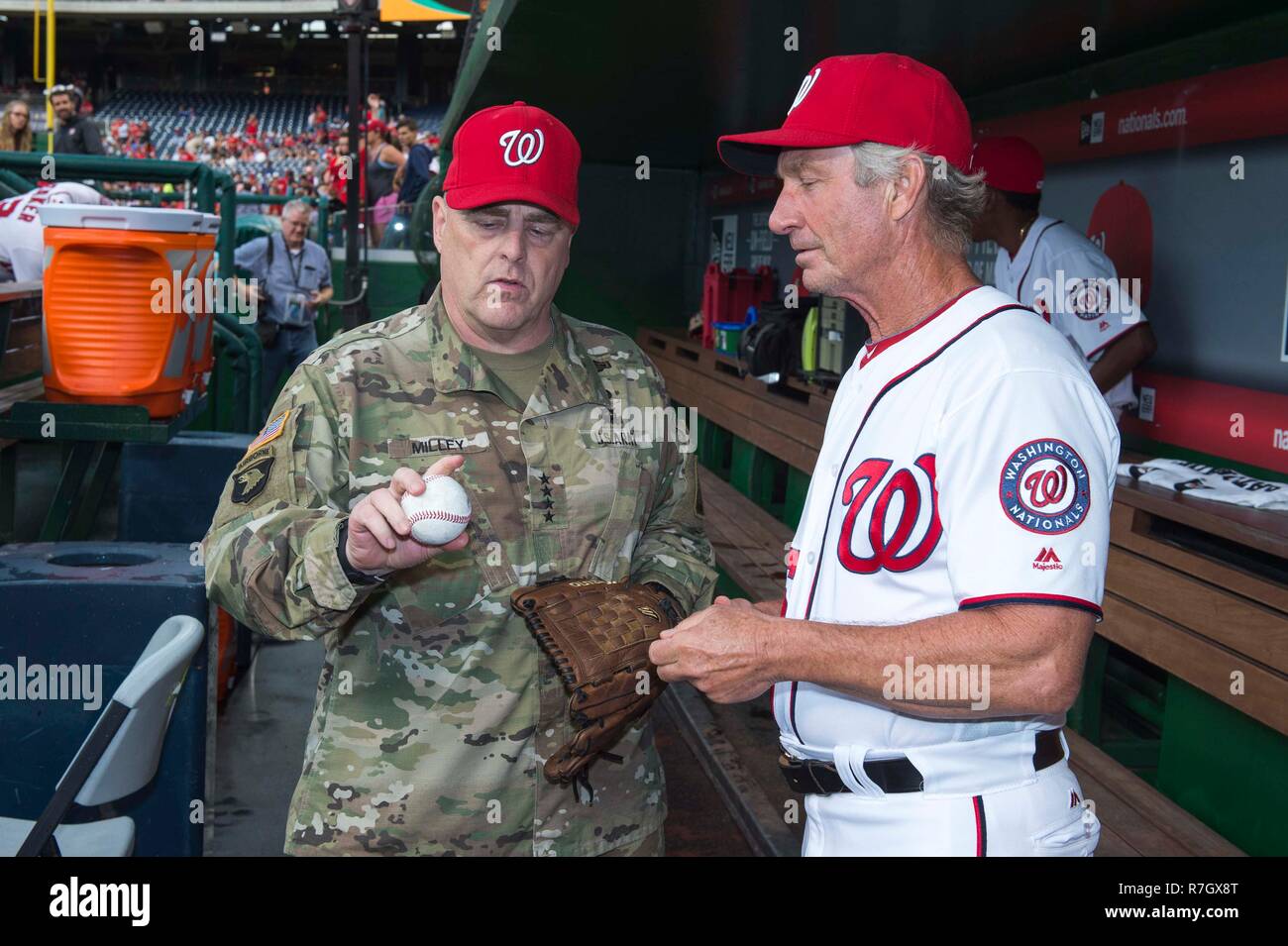 Stati Uniti Capo di Stato Maggiore dell Esercito gen. Mark Milley, a sinistra, è dato consigli a gettare il primo passo per i cittadini di Washington di baseball gioco dalla panchina coach Chris Speier esercito durante la giornata al Parco cittadini Giugno 28, 2016 a Washington, DC. Milley è stato scelto dal presidente Donald Trump su dicembre 8, 2018 a essere il prossimo presidente del Joint Chiefs. Foto Stock