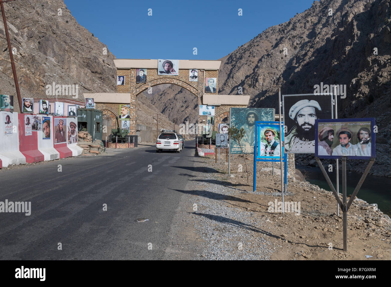 Arch segnando l'ingresso del Panjshir Valley con blocchi in calcestruzzo e poster di Massoud di seguaci, Panjshir Provincia, Afghanistan Foto Stock
