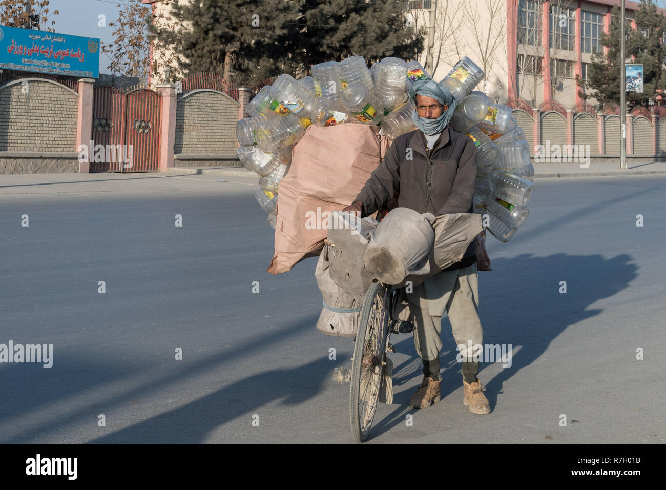 Anziani Garbage Collector in sella ad una bicicletta per le strade di Kabul, provincia di Kabul, Afghanistan Foto Stock