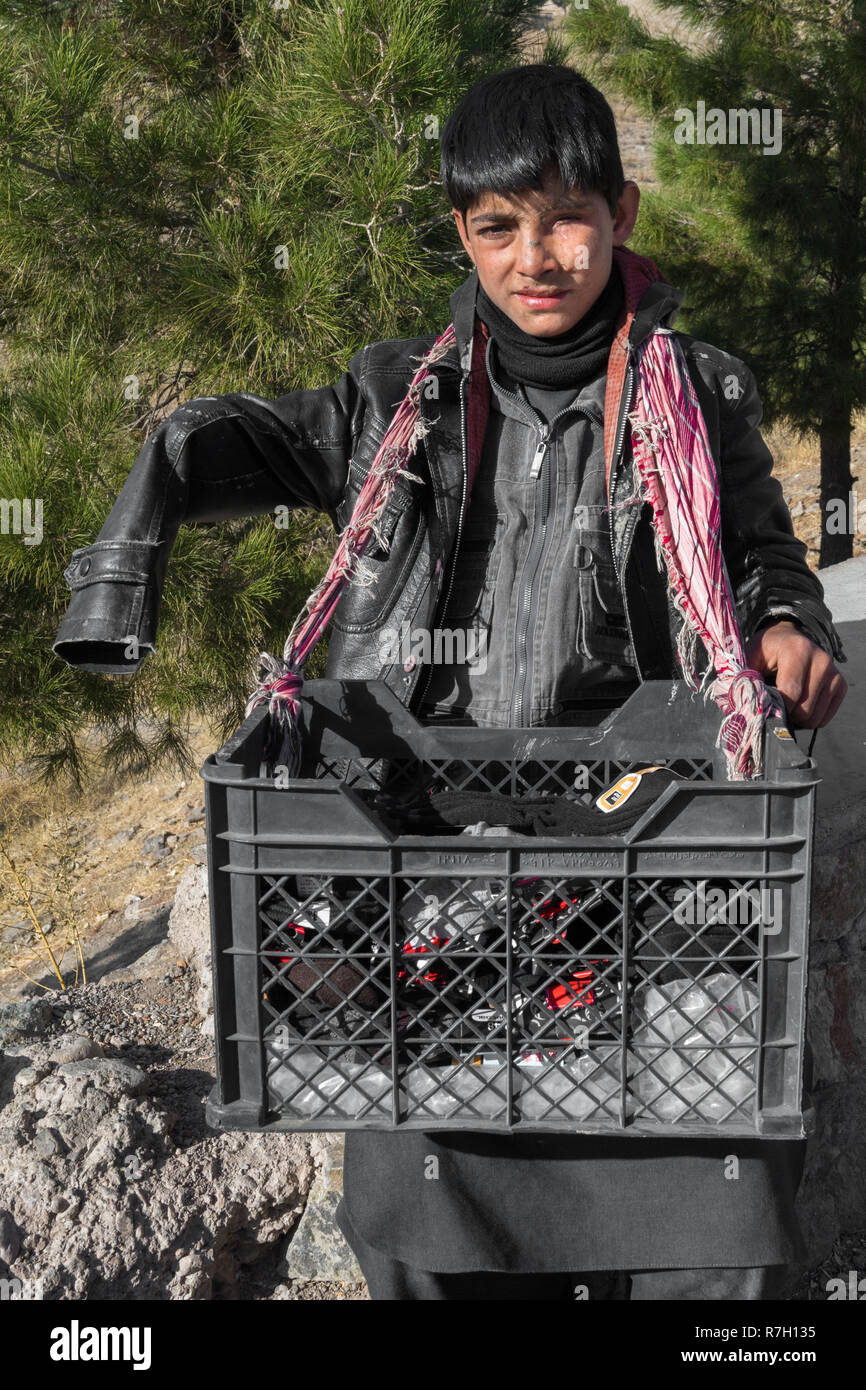 Ragazzo gravemente ferito da una mina antiuomo vende calzini sul ciglio della strada vicino a Museo della Jihad, Herat, provincia di Herat, Afghanistan Foto Stock