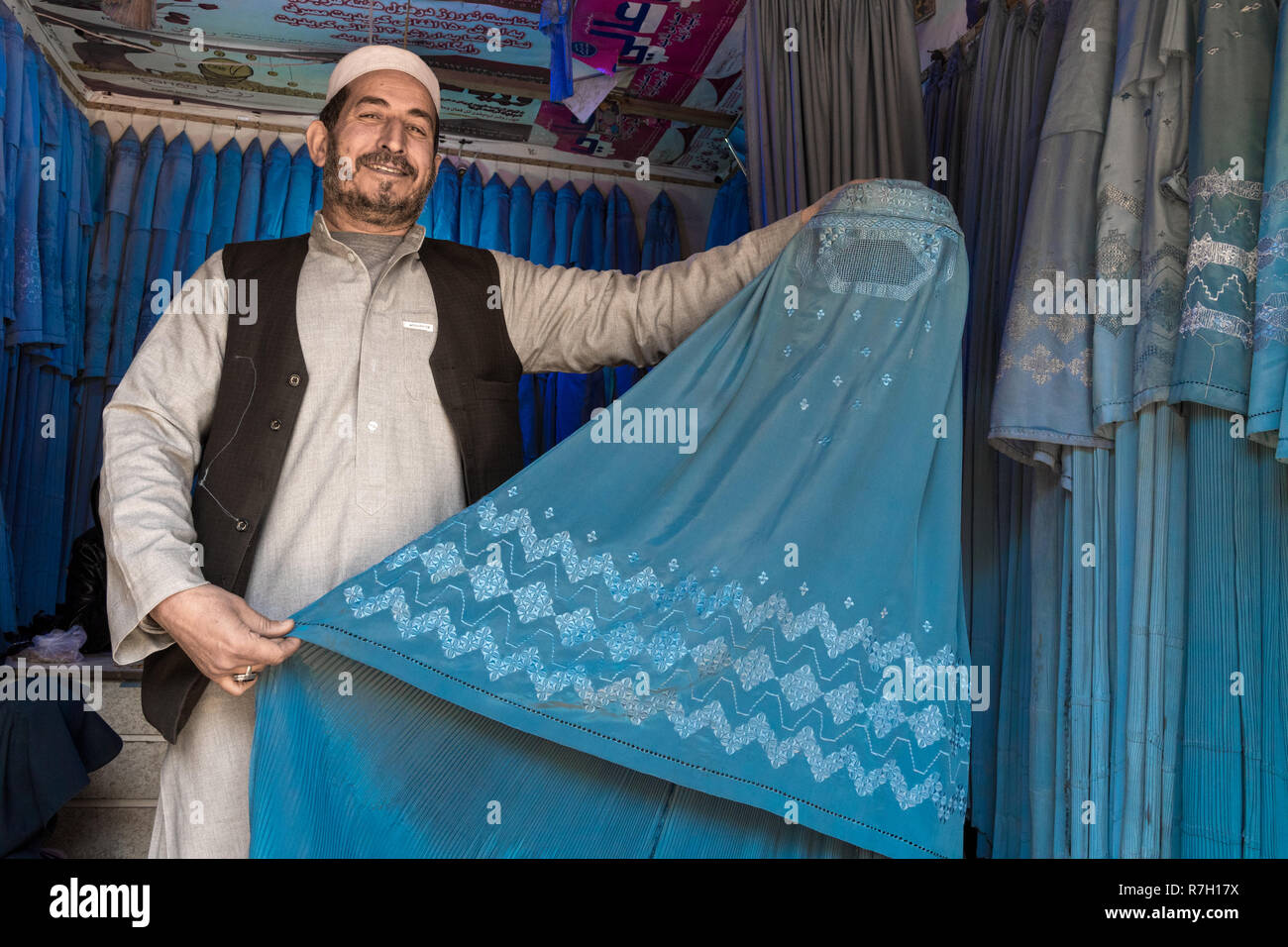 Uomo Blu Vendita Burqa nella vecchia città bazar, Herat, provincia di Herat, Afghanistan Foto Stock