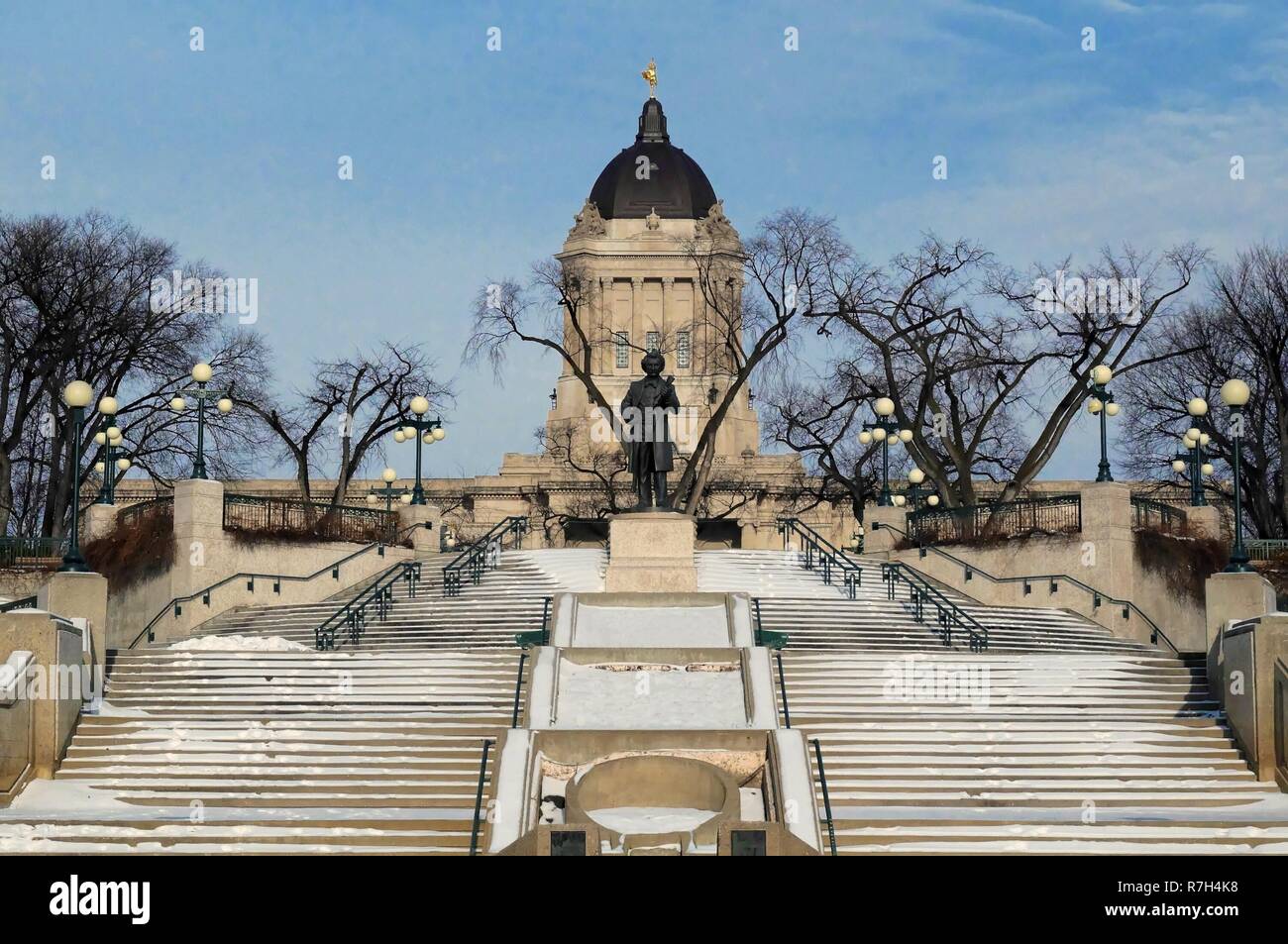 Inverno vista dalla banca del fiume Assiniboine su Manitoba legislatura edificio con Louis Riel scultura davanti. Winnipeg, Manitoba, Canada. Foto Stock