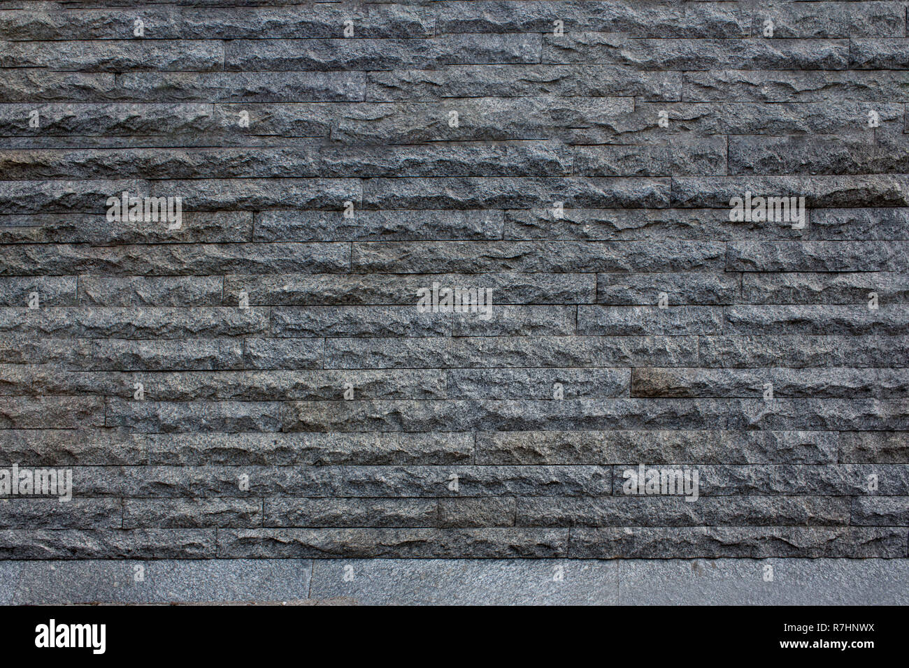 Muro di mattoni grigi. Foto Stock