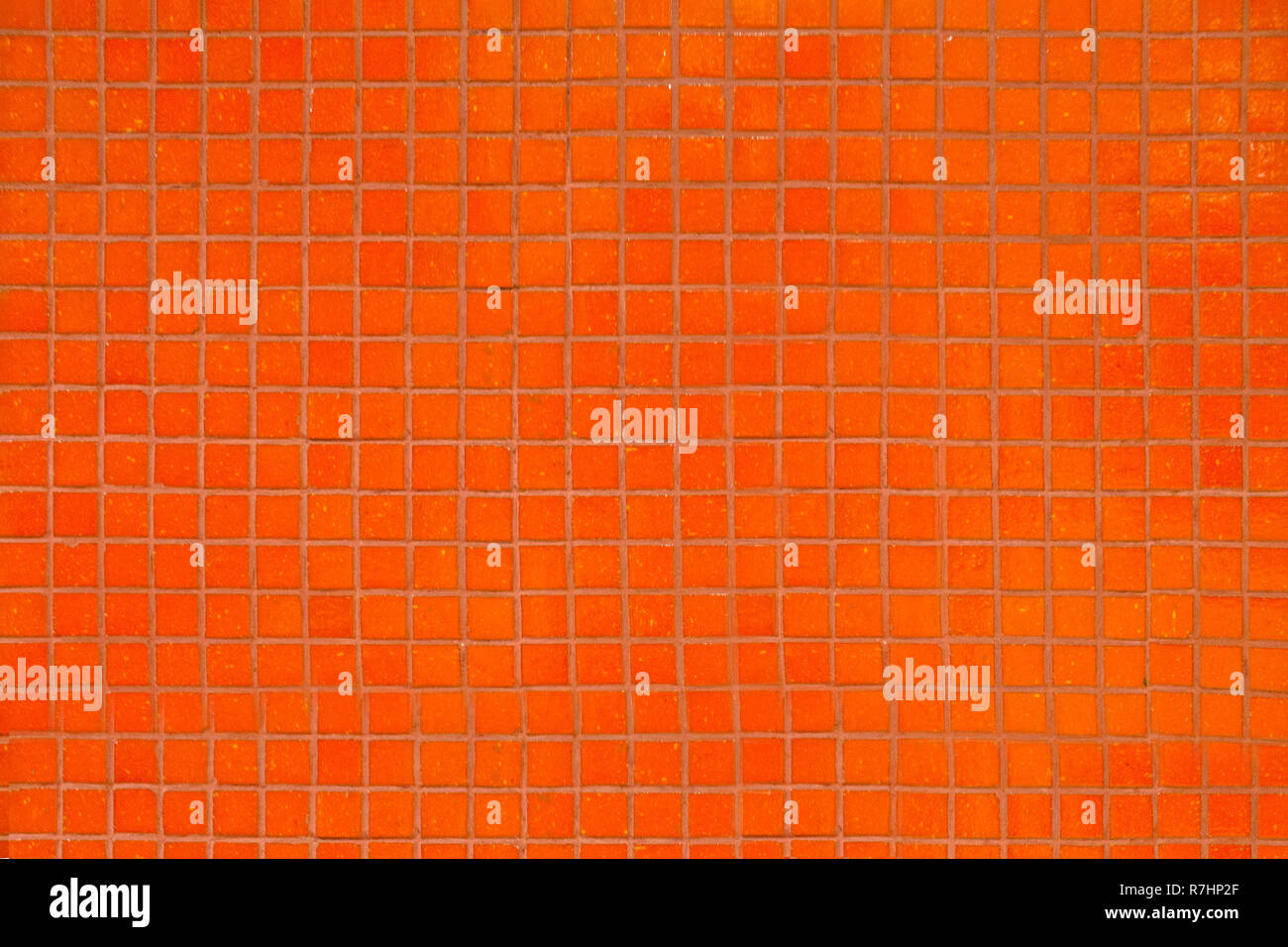 Parete piastrelle di colore arancione con piccoli quadrati di mosaico. Foto Stock