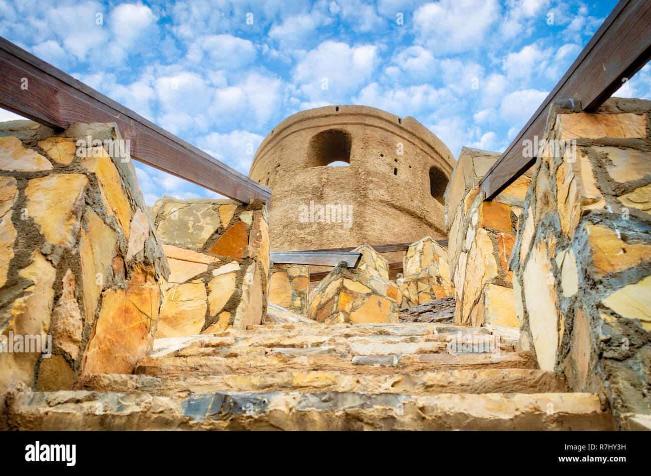 Bassa angolazione del vecchio e tradizionale scalinata di pietra calcarea con corrimano in legno per un militare abbandonato torre di avvistamento. Foto Stock