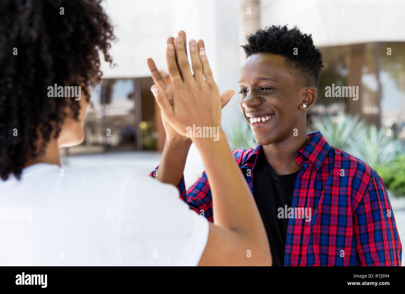 African American l uomo dà alta cinque ad un amico outdoor in città Foto Stock