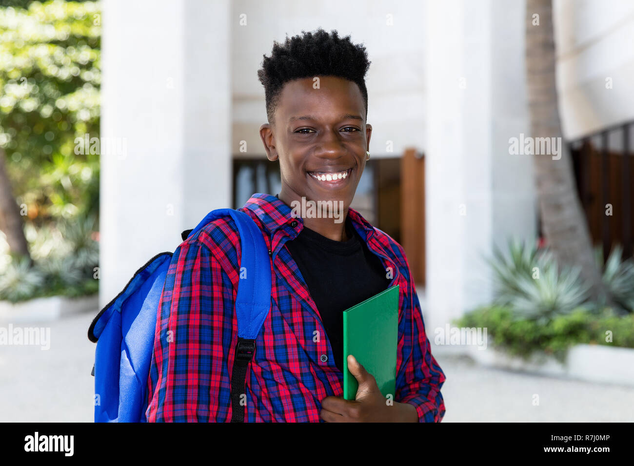 Americano africano studente maschio con libro all'aperto in città Foto Stock