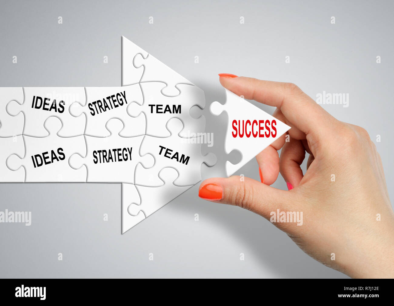 Via del successo attraverso idee, strategia e team, mano costruisce la freccia con puzzle Foto Stock