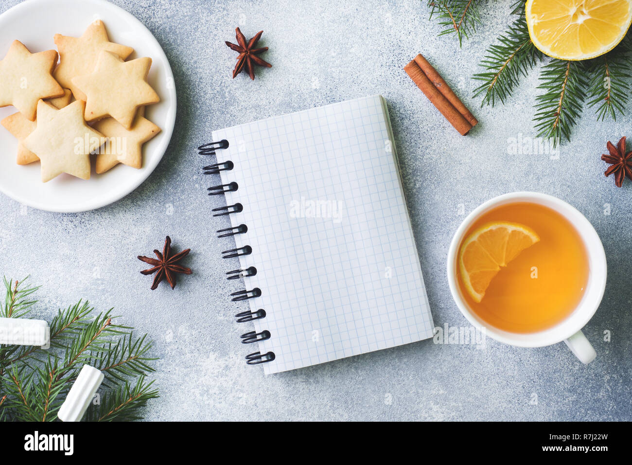 Tazza di tè e biscotti, rami di pino, bastoncini di cannella, anice stelle. Natale, concetto d'inverno. Lay piatto vista dall'alto. Foto Stock