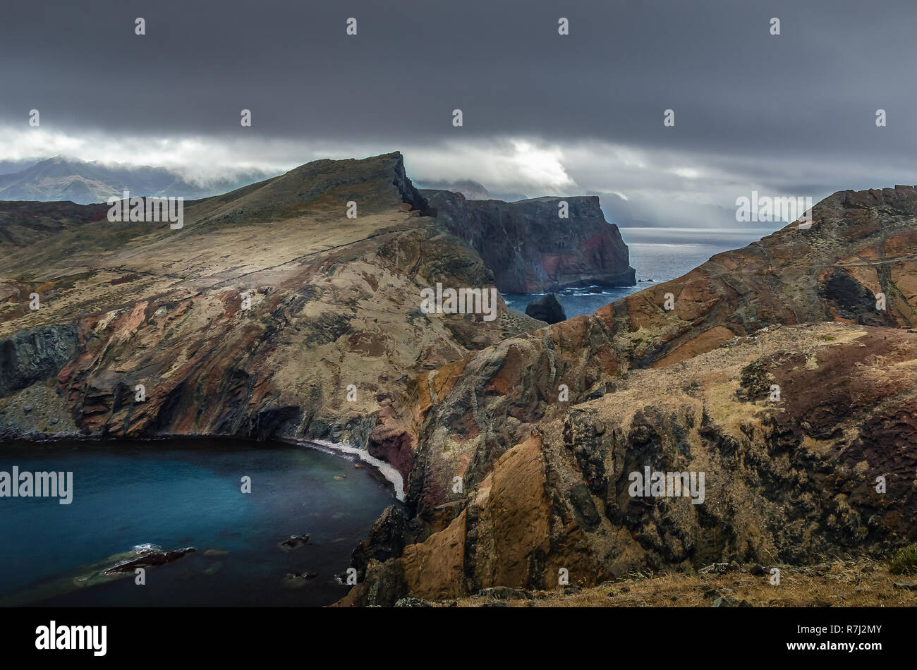 Drammatica moody bellissimo paesaggio con ripide Capo orientale costa dell'isola di Madeira, lavato dall oceano Atlantico. Rocce colorate sono coperti da un secco Foto Stock