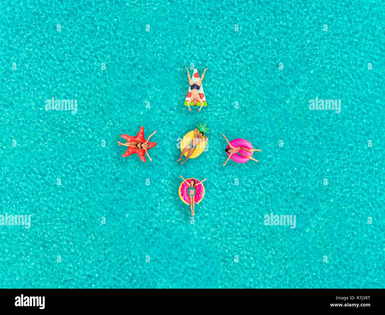 Vista aerea del popolo sul galleggiante gonfiabile di pizza, flamingo, stella, ananas e a forma di ciambella materassi, in formazione. Foto Stock