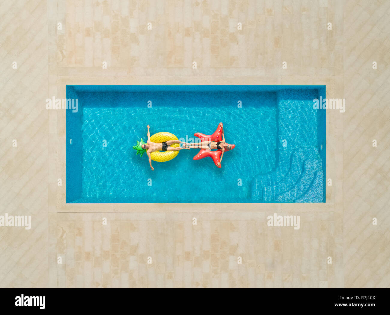 Vista aerea della donna e un uomo sul materasso gonfiabile in piscina. Foto Stock