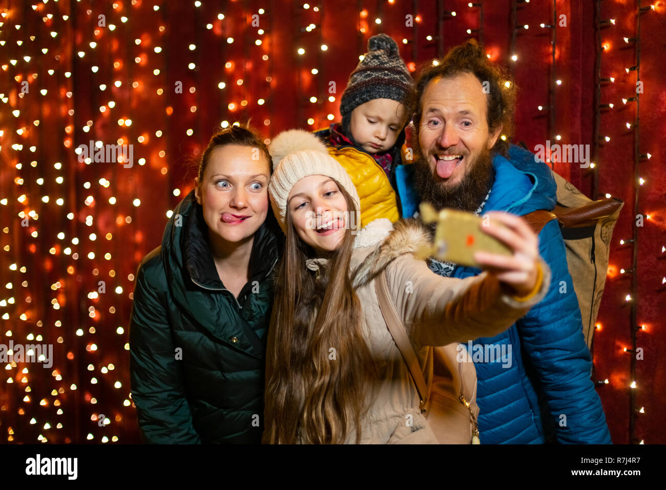 Figlia di prendere selfie con la famiglia al mercato di Natale. Foto Stock