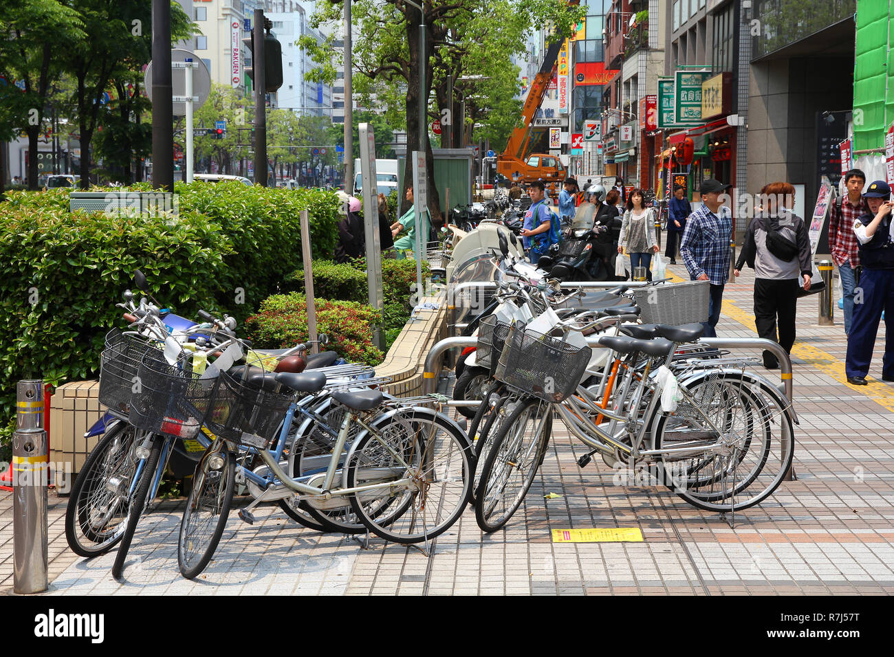 KAWASAKI, Giappone - 10 Maggio: le persone camminare per le biciclette parcheggiate su 10 Maggio 2012 in Kawasaki, Giappone. La bicicletta è uno dei più popolari modi di trasporto in Kawasak Foto Stock