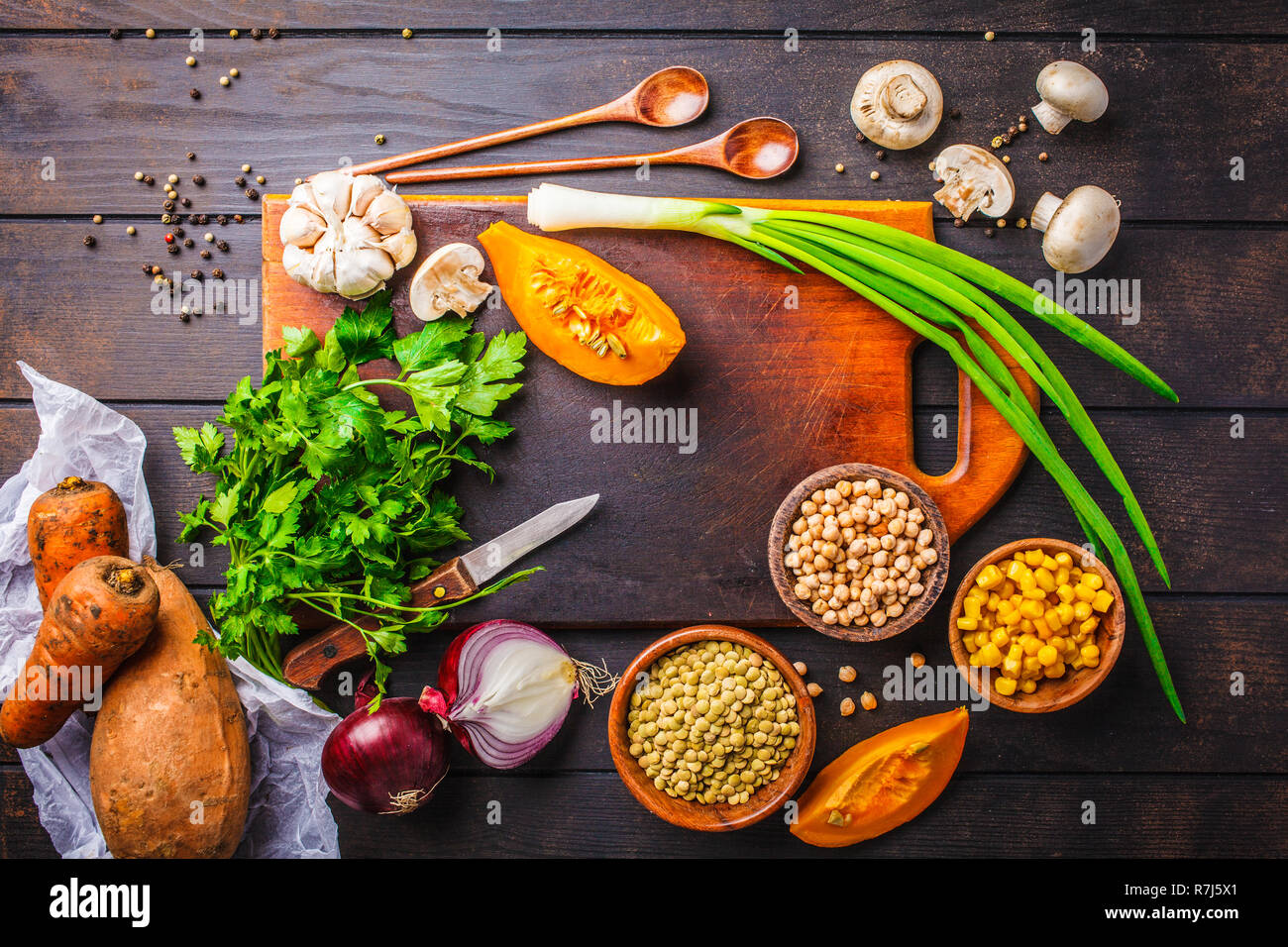 Ingredienti per vegetale vegan zuppa di lenticchie, i funghi e i ceci al buio su un sfondo di legno, vista dall'alto. Foto Stock
