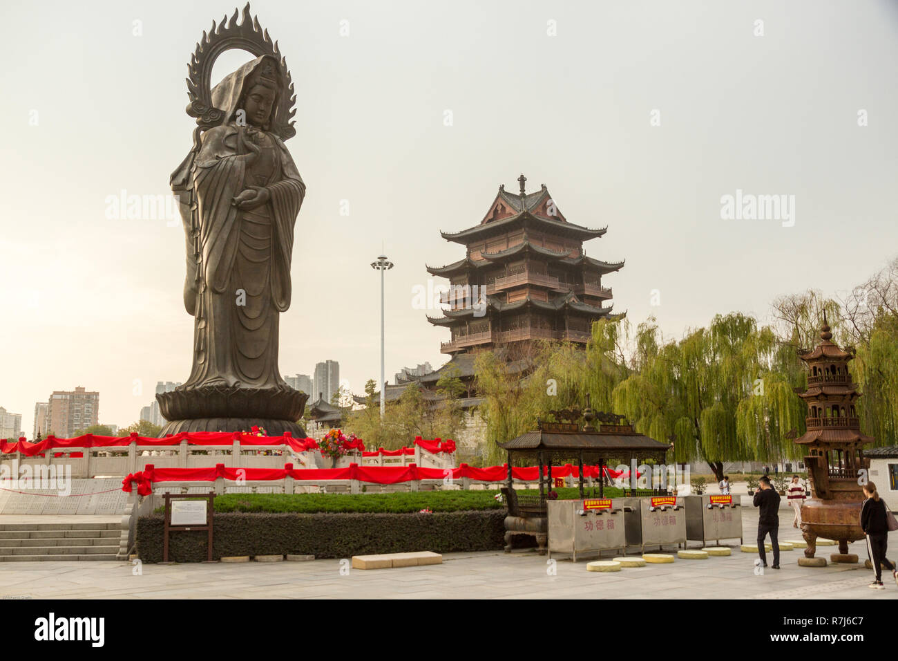 Guanying statua del Buddha a Guiyuan tempio buddista a Wuhan Hubei Cina. Statua troneggia sul cortile, tower è in background. Foto Stock Guanying statua del Buddha a Guiyuan tempio buddista a Wuhan Hubei Cina. Statua troneggia sul cortile, tower è in background. Foto Stock