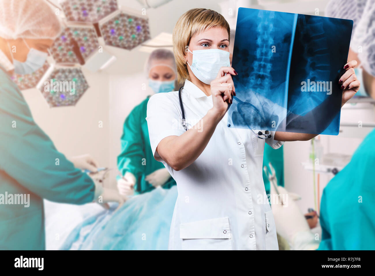 Medico donna guardando un x-ray della colonna vertebrale. Oltre la chirurgia shot sfondo. Foto Stock