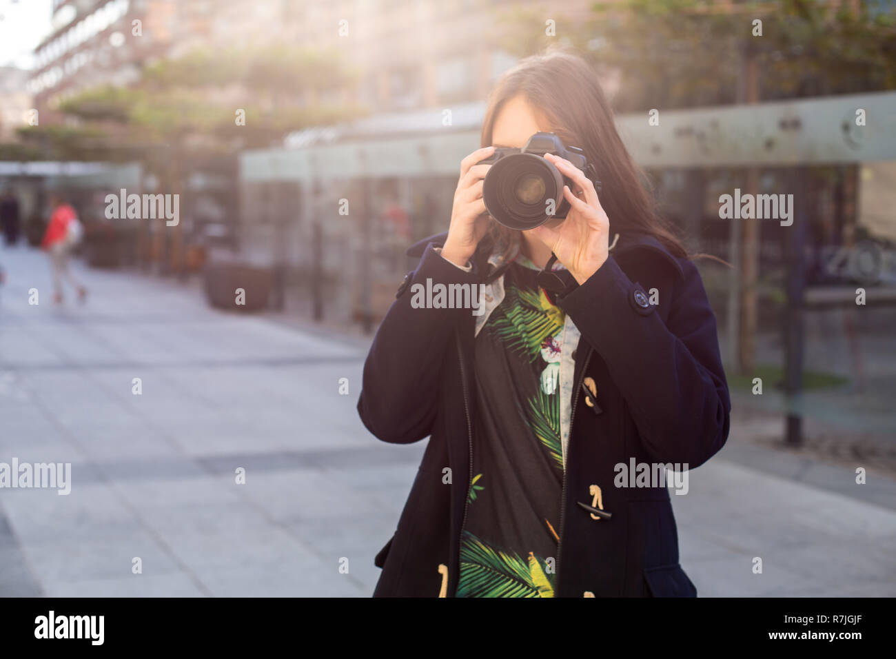 Attrazione turistica fotografo di donna con la telecamera per esterno in strada della citta'. Sun flare Foto Stock