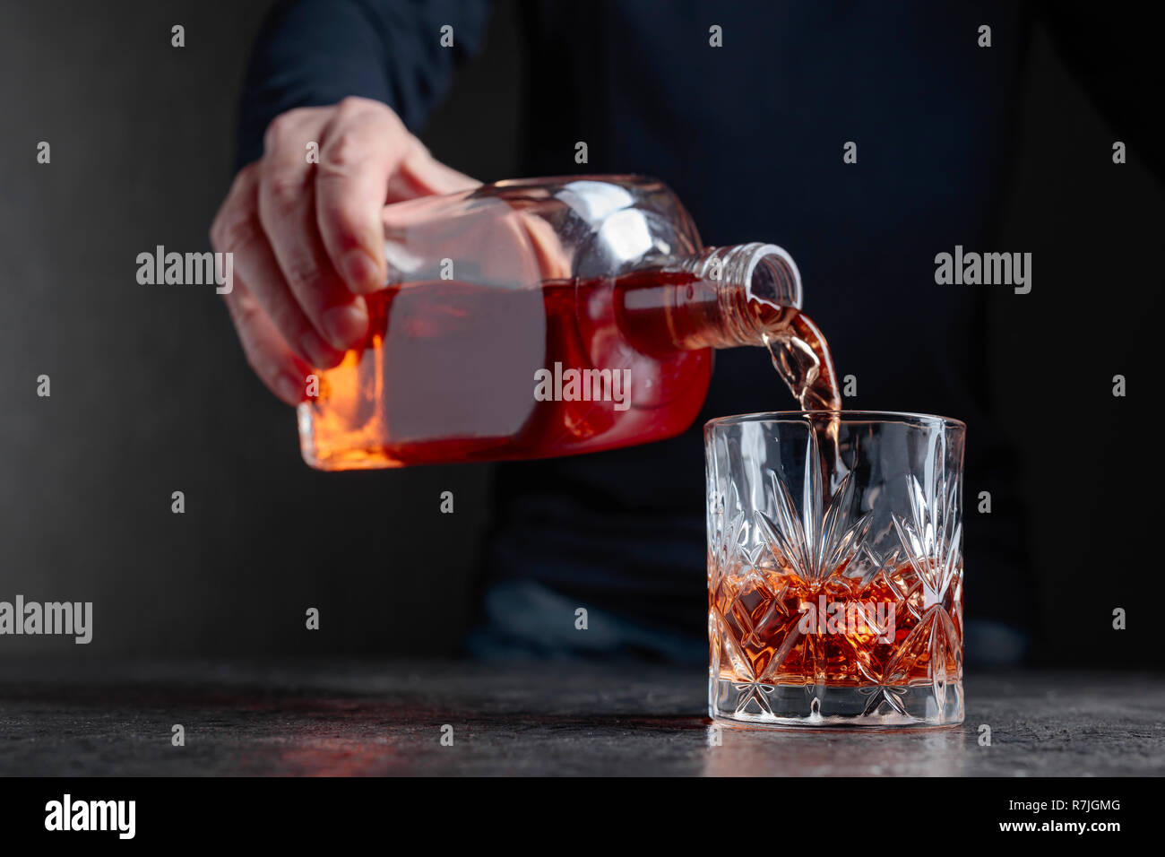 Barman versa whiskey in un vetro al bar. Messa a fuoco selettiva. Foto Stock