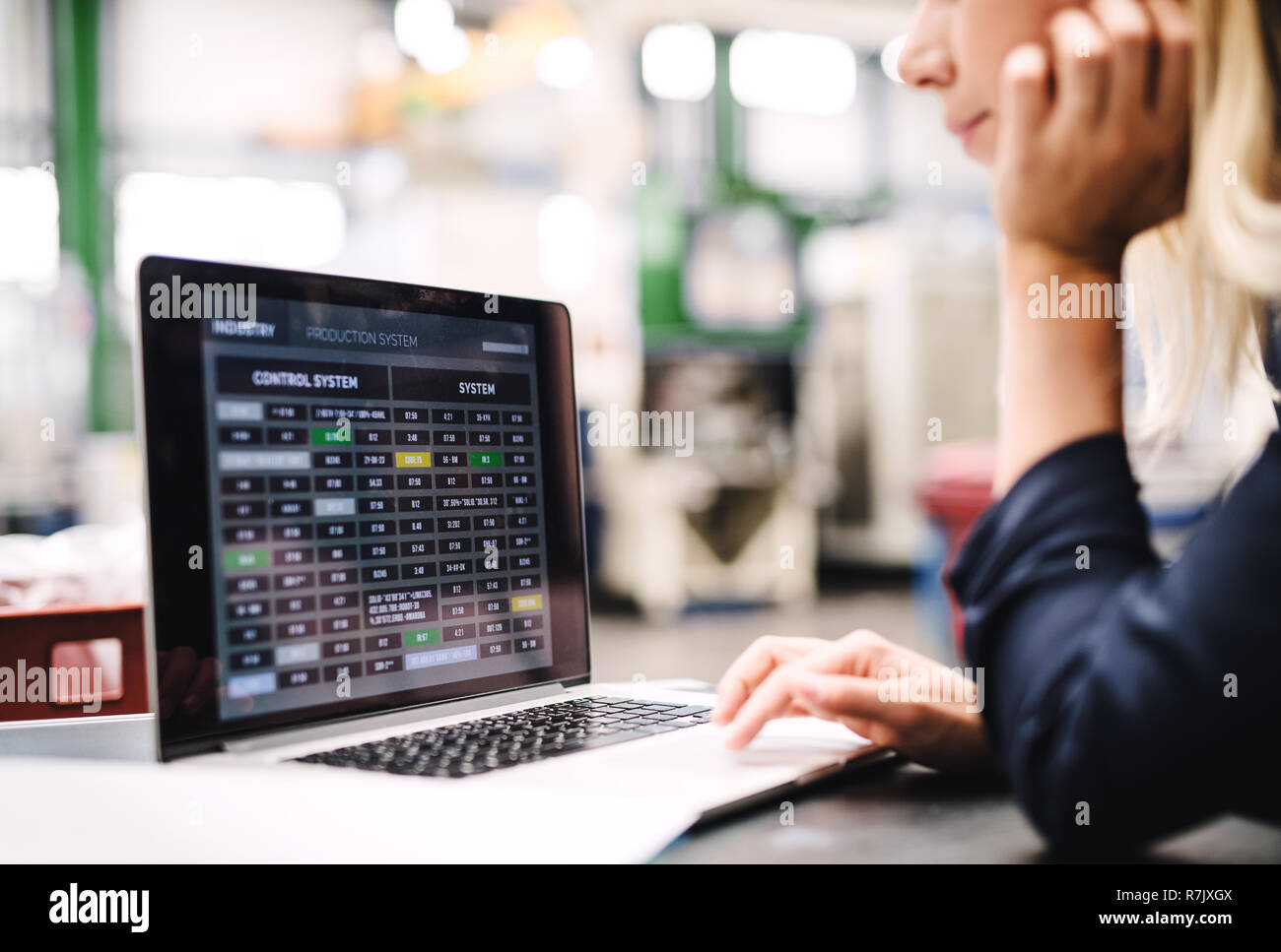 Una donna industriale ingegnere in una fabbrica utilizzando laptop. Foto Stock