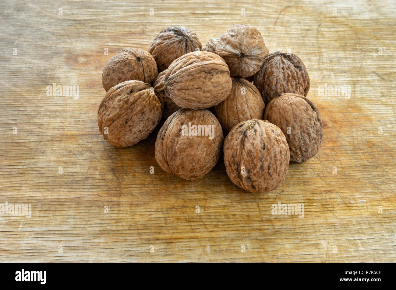 Pila di mature noci organico giacente su di una superficie di legno Foto Stock