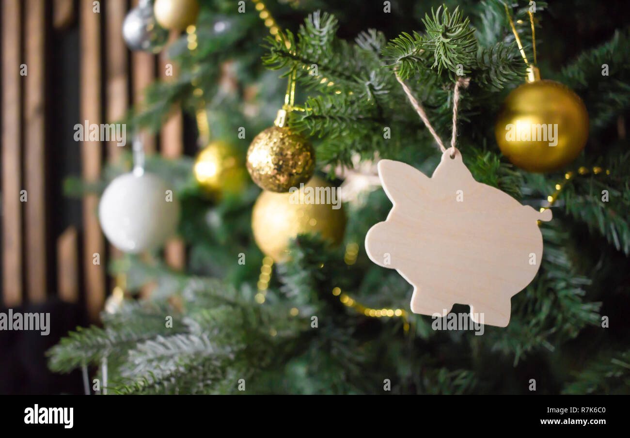 Giocattolo di suino l'albero di Natale. Palline dorate, perline, altre decorazioni. Anno nuovo concetto di simbolo. Foto Stock