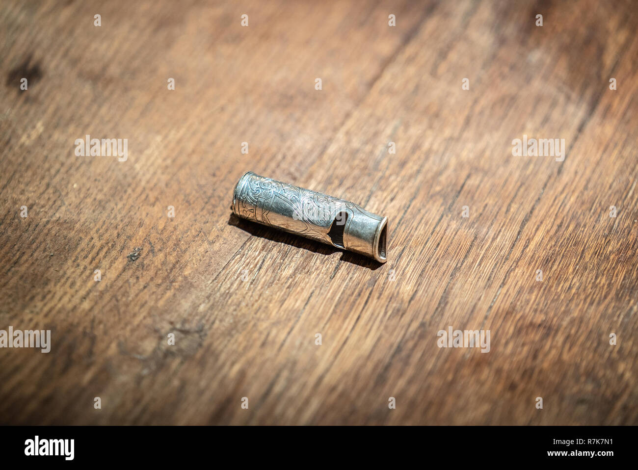 Metallo color argento fischio del cane sul tavolo di legno Foto Stock