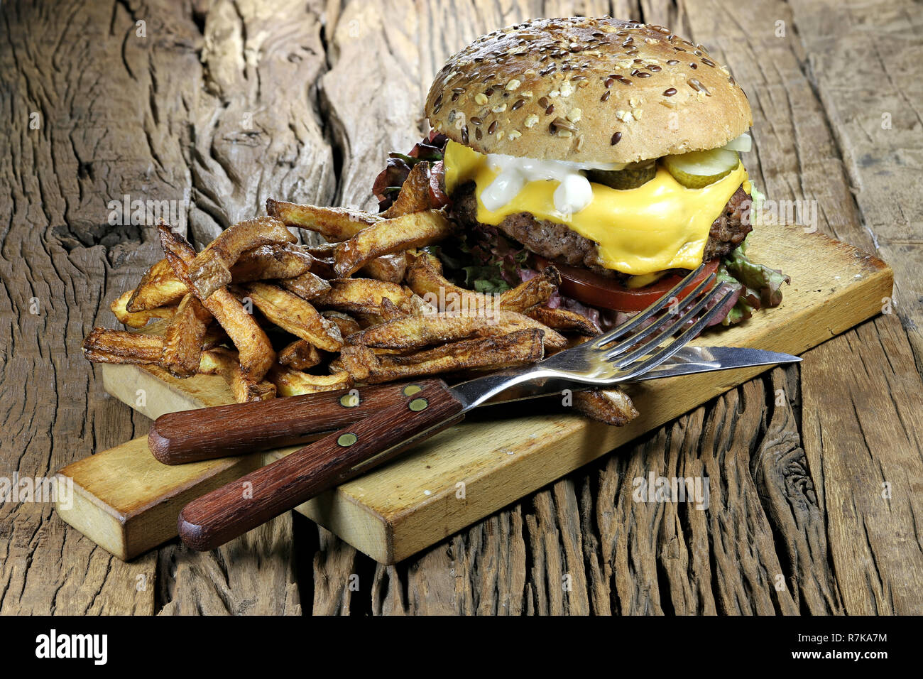 In casa cheeseburger e patatine fritte sul rustico sfondo di legno Foto Stock