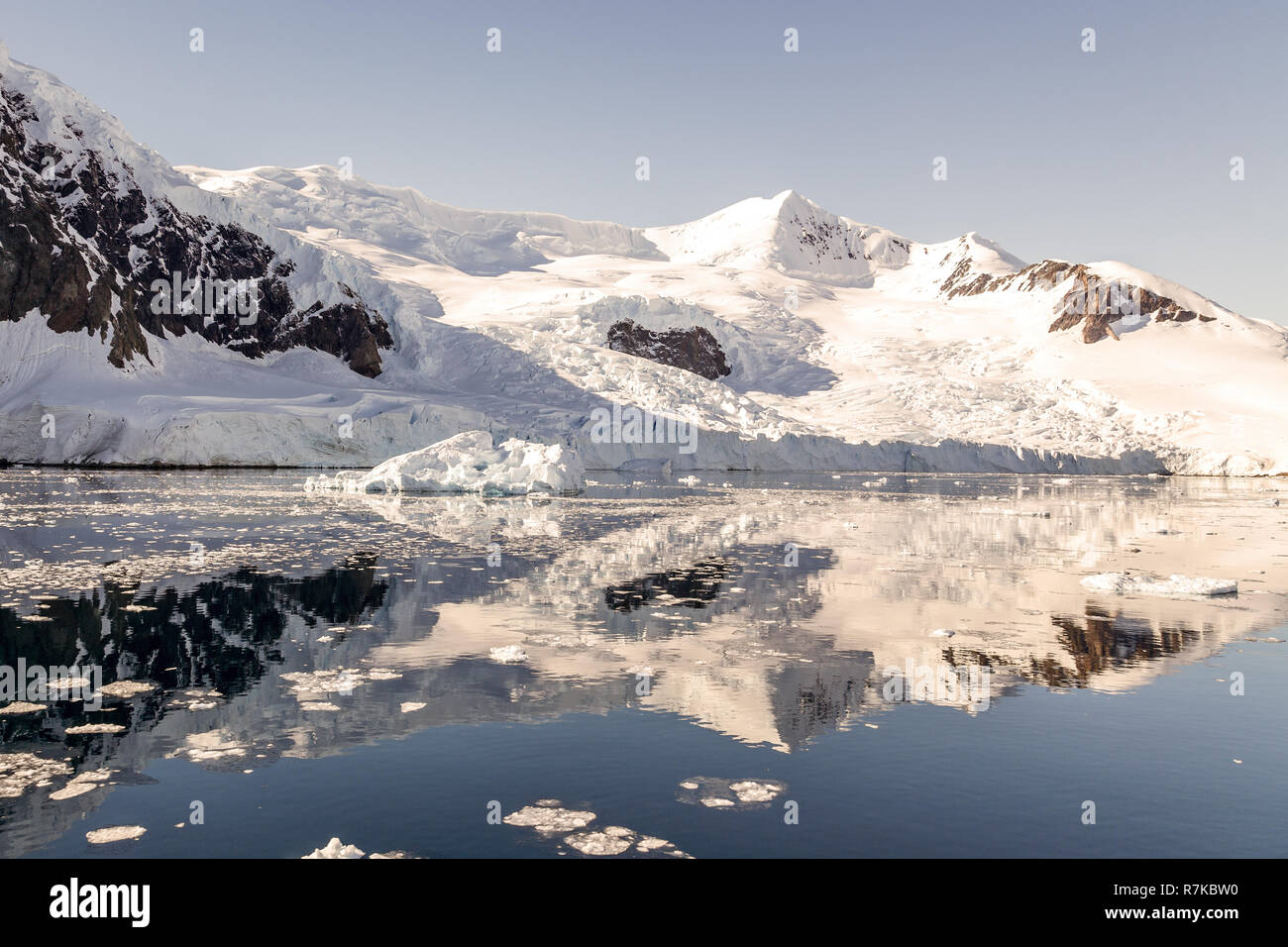 Montagna innevata e il ghiacciaio riflessa nelle acque antartiche di baia Neko, Antartide Foto Stock