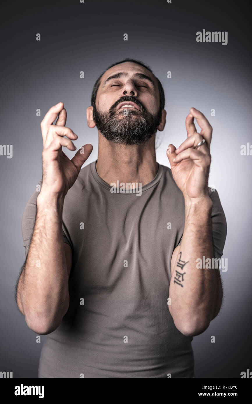 Ritratto di uomo caucasico attraversando il dito con gli occhi chiusi Foto Stock