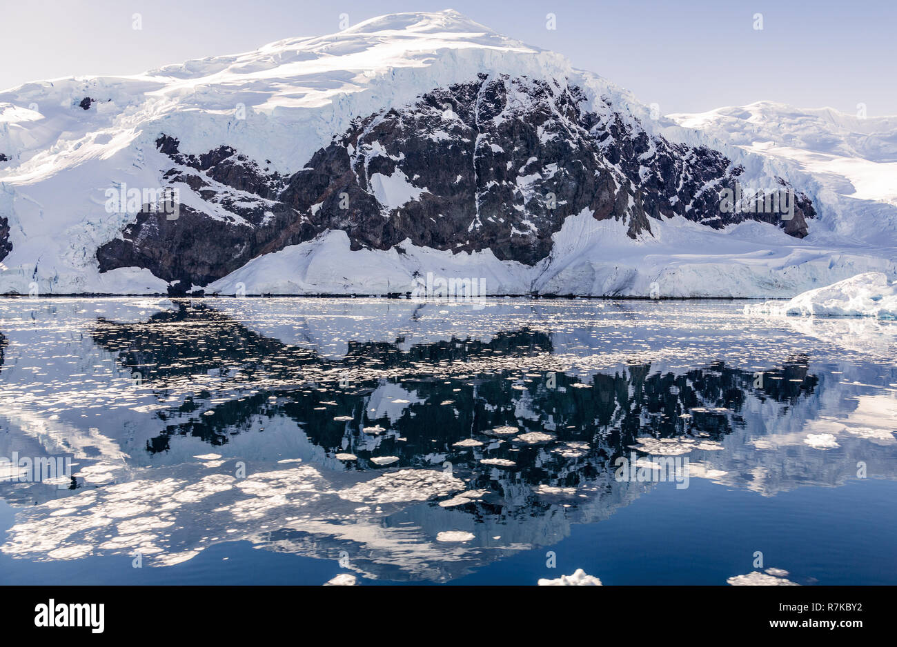 Montagna innevata e il ghiacciaio riflessa nelle acque antartiche di baia Neko, Antartide Foto Stock