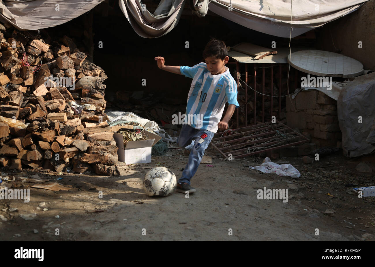 A Kabul, Afghanistan. L'8 dicembre, 2018. Afghanistan poco messi fan Murtaza Ahmadi, indossando una maglietta firmata da Argentina giocatore di calcio Lionel Messi, gioca a calcio a Kabul, capitale dell'Afghanistan, dic8, 2018. Credito: Rahmat Alizadah/Xinhua/Alamy Live News Foto Stock