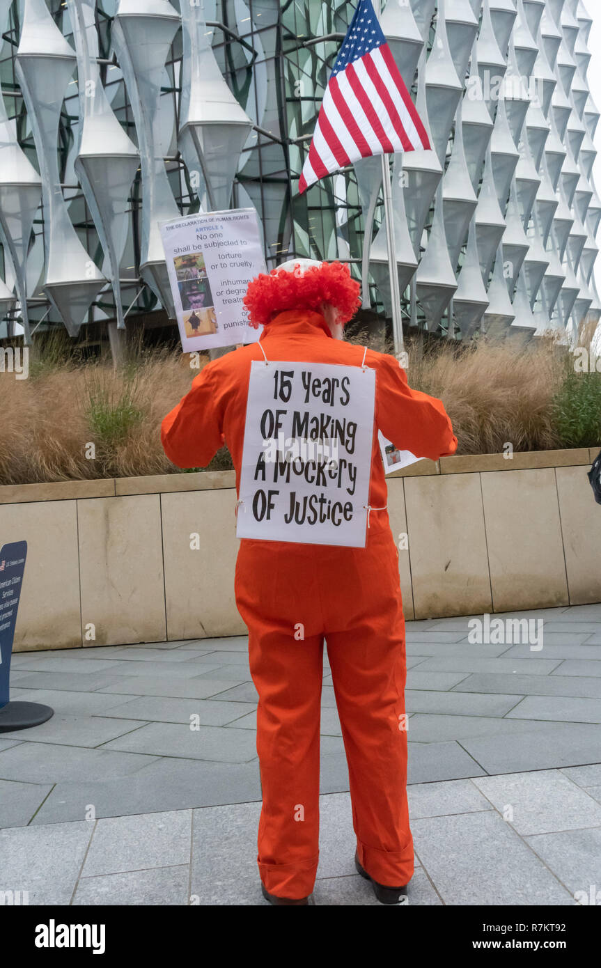 Londra, Regno Unito. Il 10 dicembre 2018. Un manifestante vestito in tuta arancione con un clown parrucca di fronte all'Ambasciata degli Stati Uniti nella finale "hut Guantanamo!" protesta mensile del 2018 in occasione del settantesimo anniversario della Dichiarazione Universale dei Diritti dell'Uomo (UDHR). Questo dichiarata "Nessuno può essere sottoposto a tortura né a pene o trattamenti crudeli, inumani o degradanti " e " Nessun individuo potrà essere arbitrariamente arrestato, detenuto o esiliato.' Guantanamo ha ancora 40 detenuti che sono stati torturati e detenuti in detenzione senza processo per quasi 17 anni. Credito: Peter Marshall / Alamy Live News Foto Stock