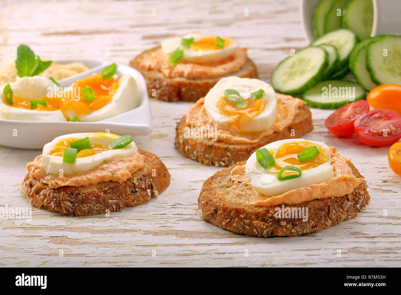 Panini con pasta di salmone e uova di colore bianco su sfondo di legno Foto Stock