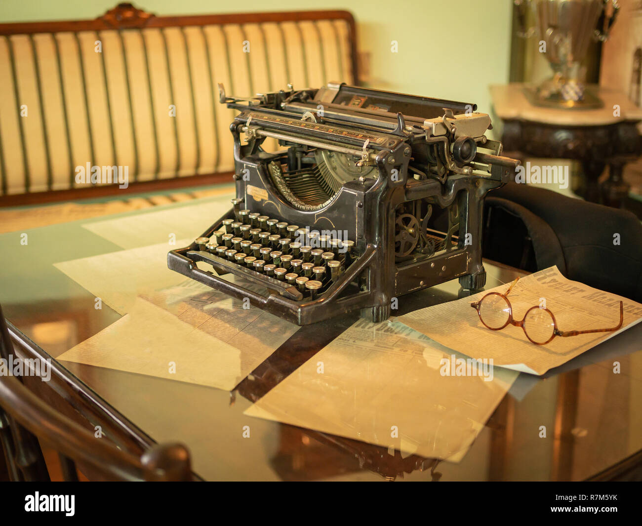 Vintage scrivania con la vecchia macchina da scrivere e oldstyle bicchieri arrotondati su di esso Foto Stock