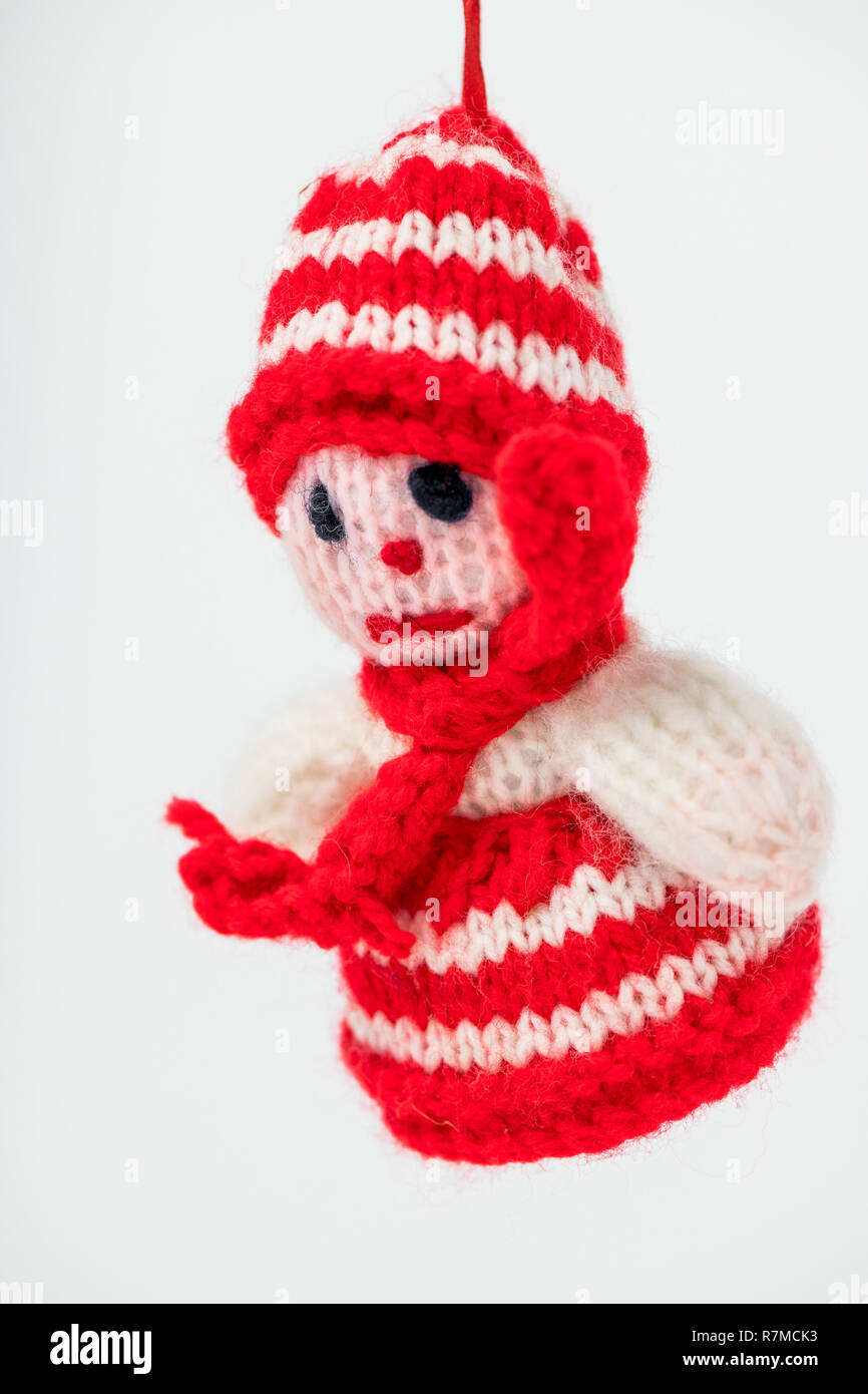 Bianco maglia pupazzo di neve con un rosso e bianco wooly hat e il ponticello ed una sciarpa rossa utilizzato come una decorazione di Natale. Foto Stock