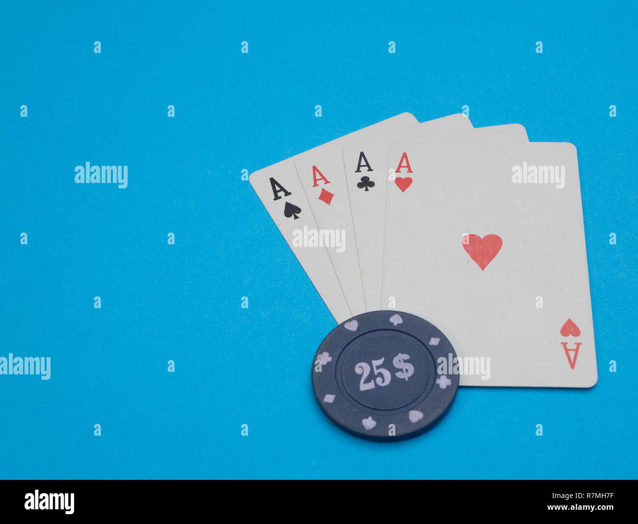 Quattro carte aces con casino 25 dollar chip su sfondo blu Foto Stock
