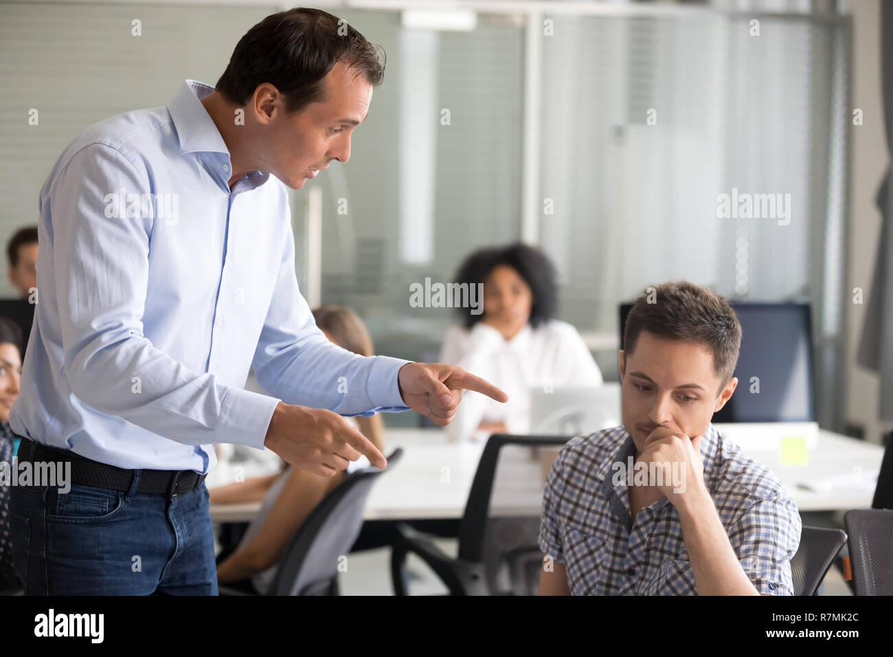 Arrabbiato boss è scolding frustrato incompetente dipendente Foto Stock