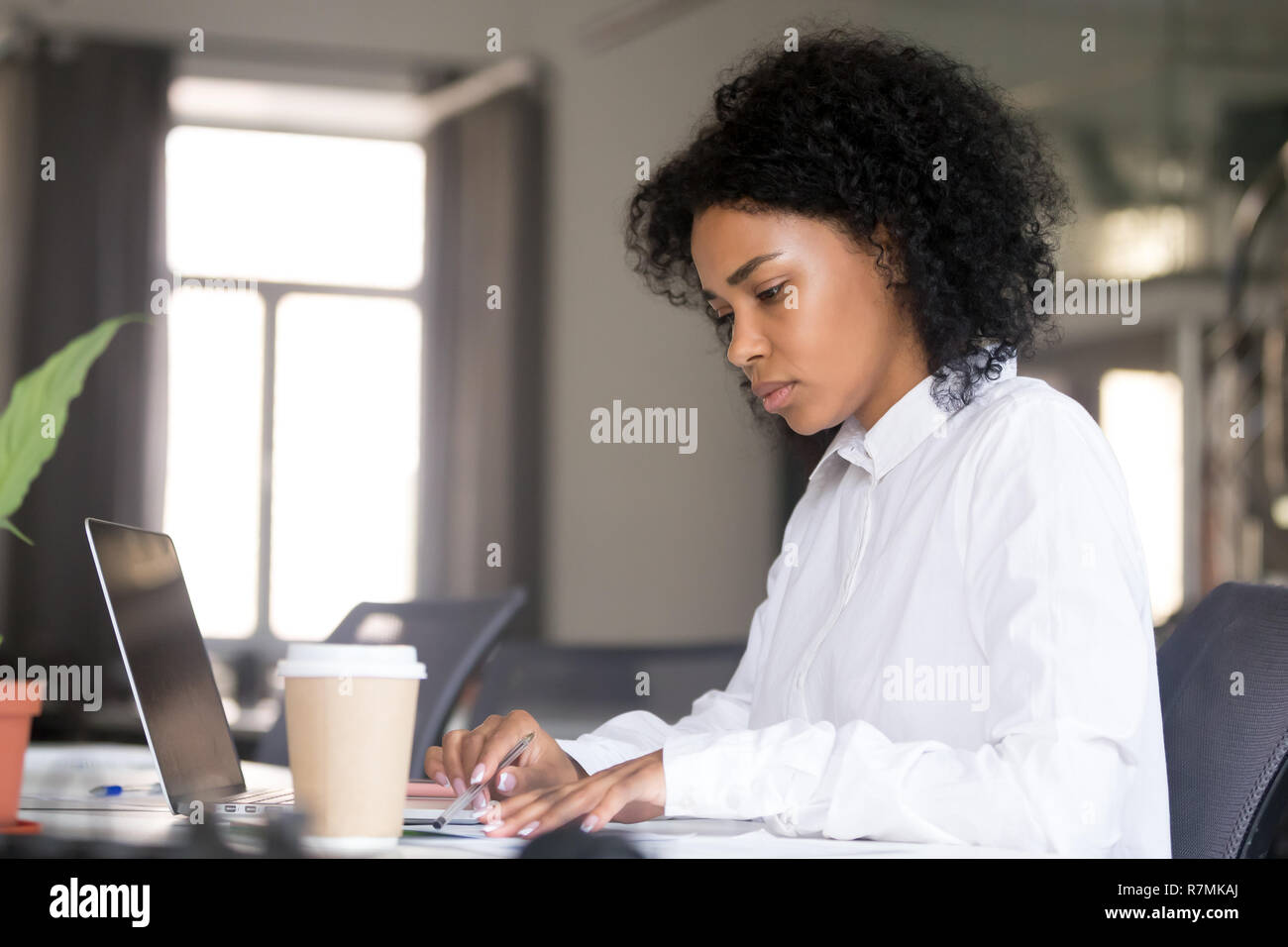 Grave americano africano donna che lavorano con documenti a workpla Foto Stock