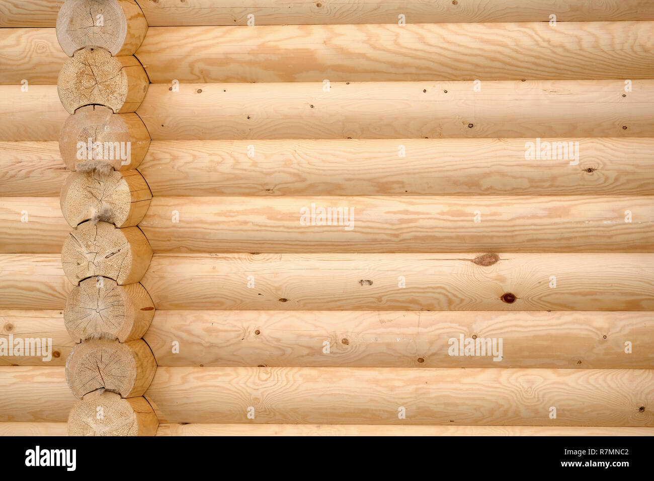 Parete di legno casa di paese piegato da marrone chiaro liscia registri piallati close-up vista frontale come sfondo Foto Stock