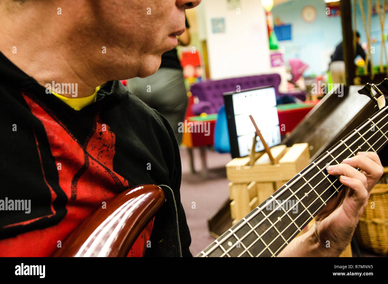 Ingrandimento di foto di electric bass guitar giocatore giocare con le mani Foto Stock