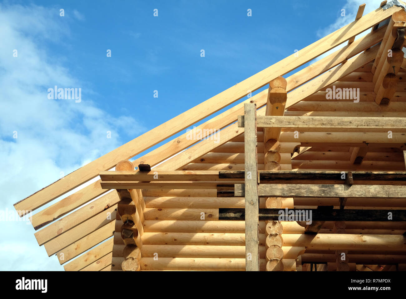 Processo di casa in legno dritto pendenza del tetto montaggio vista anteriore. Paese di legno Costruzione casa Foto Stock