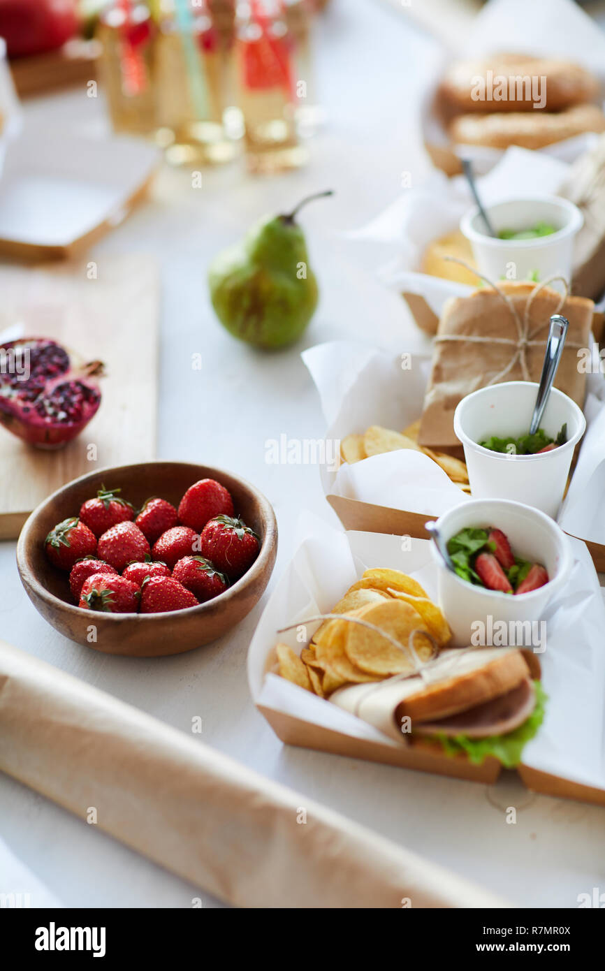 Angolo alto sullo sfondo di un partito rustico tavolo con vari cibi sani, frutta, panini e bevande limonata Foto Stock