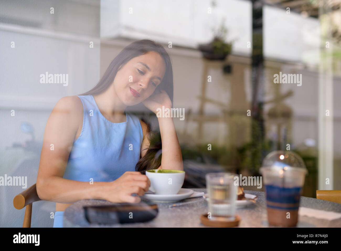 Giovani belle multi-etnico imprenditrice pensare mentre si beve il caffè mediante la finestra Foto Stock