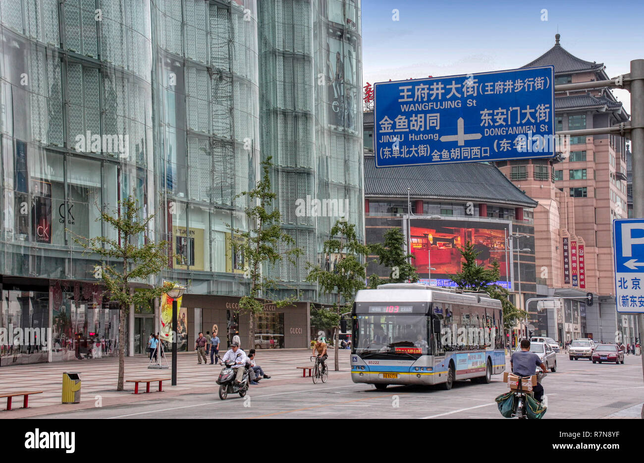 Wangfujing Street city center shopping con persone, bus, auto, scooters. l uomo Bicicletta Equitazione, Pechino, Cina Foto Stock