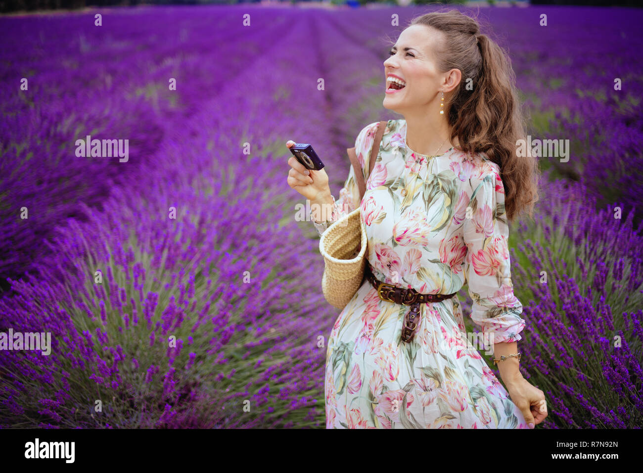 Felice giovane donna prendendo foto con una fotocamera digitale nel campo di lavanda in Provenza, Francia. In viaggio con una telecamera. Incredibile viola i campi di lavanda di Prov Foto Stock