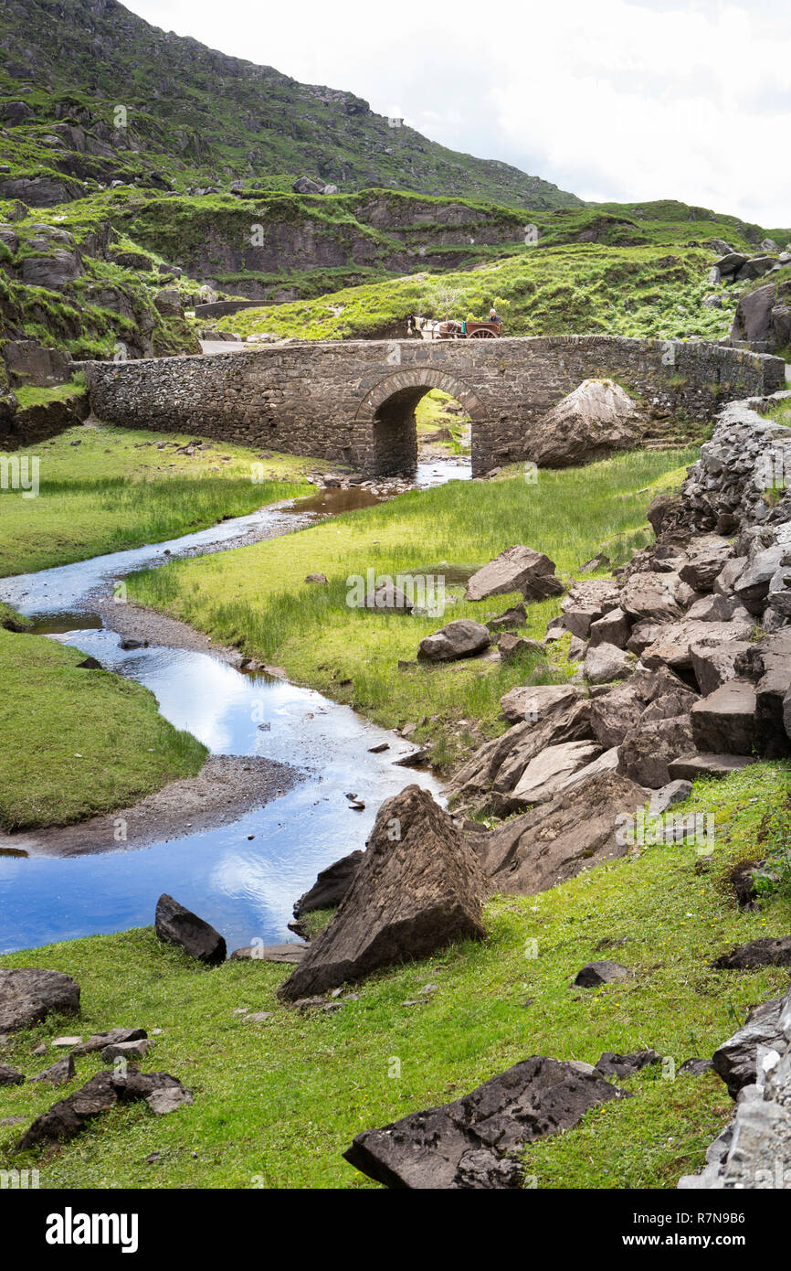 Pullman e cavallo su un ponte in pietra, Gap di Dunloe, Irlanda. Foto Stock