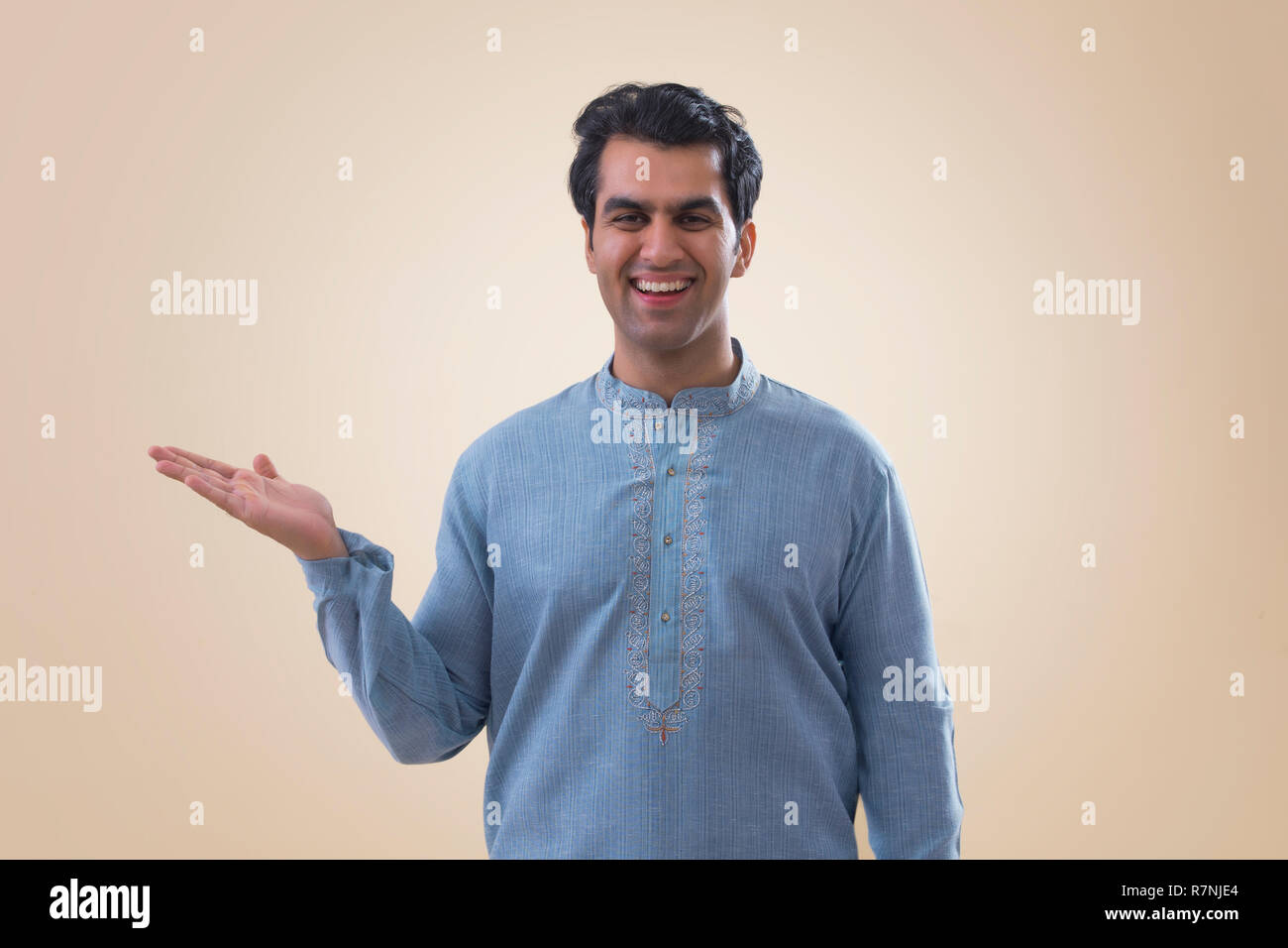 Ritratto di un sorridente giovane uomo che mostra aprire Palm. Foto Stock