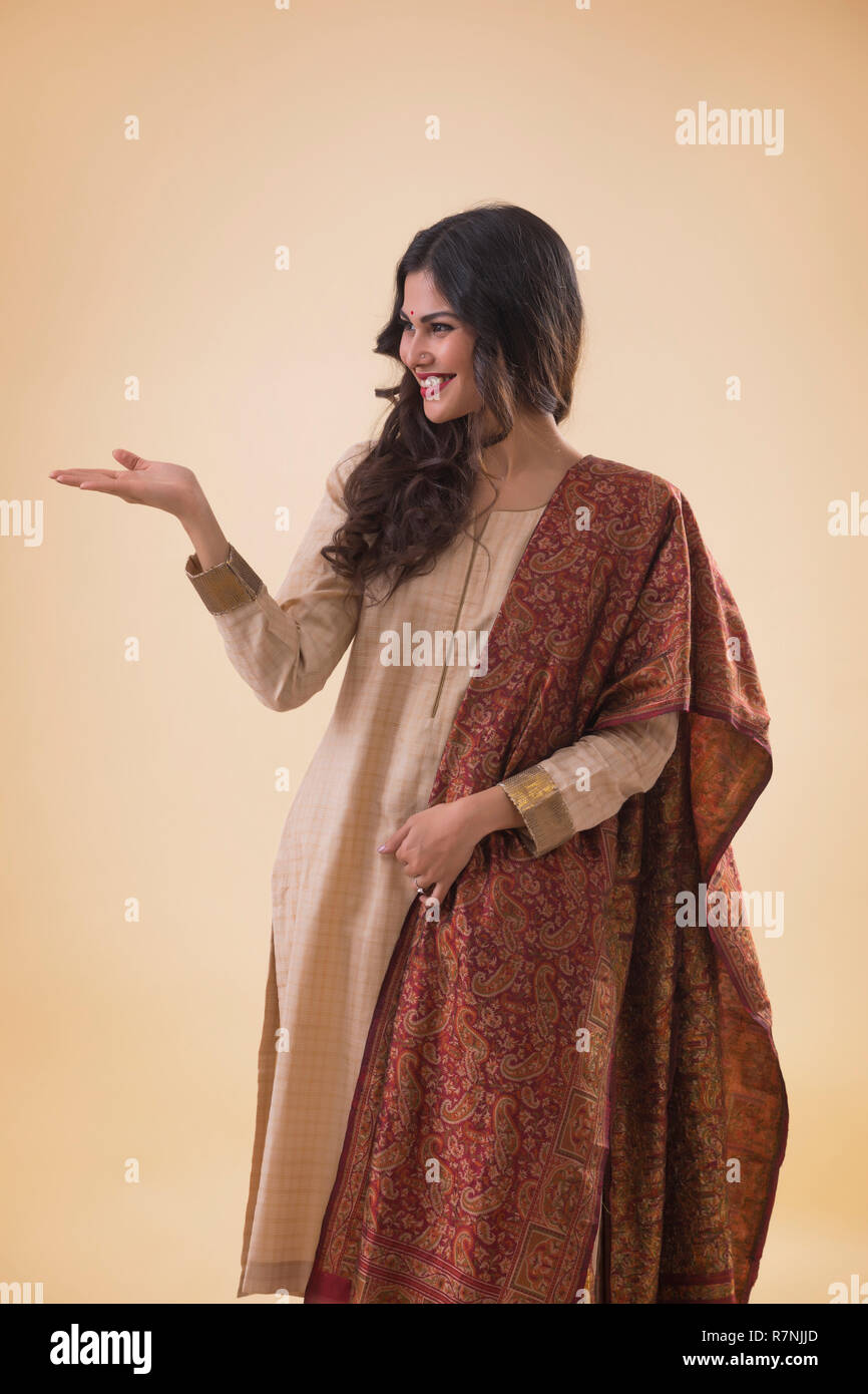 Ritratto di un sorridente giovane donna in abito tradizionale mostra aprire Palm. Foto Stock