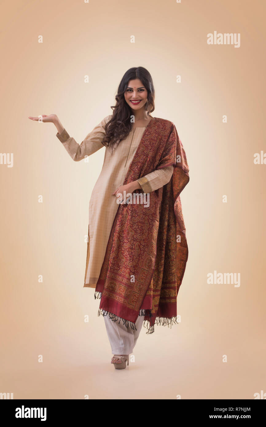 Ritratto di un sorridente giovane donna in abito tradizionale mostra aprire Palm. Foto Stock